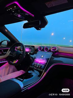 the interior of a car with purple lights and electronic devices on the dash board in front of it