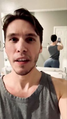 a young man taking a selfie in the mirror