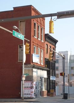 an intersection with traffic lights, street signs and buildings in the background on a sunny day