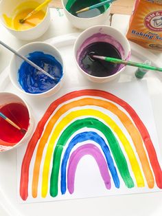 the rainbow is painted with watercolors and paintbrushes