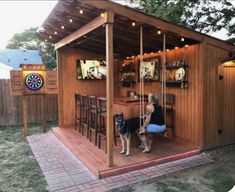 a woman and her dog are sitting in a backyard bar