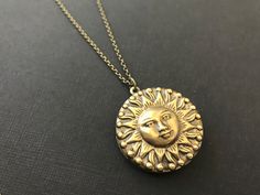 Bold Sun Hidden Locket Necklace... This celestial sun locket has an antique brass finish and is attached to an antique brass round locket. The chain is a non tarnish soldered antique brass rolo chain that closes with a lobster claw clasp. This is a unisex locket and would be a great gift for women and men! Locket - 1.25 inches in diameter (31.75mm) Interior photo area - 24mm Chain - 24 inches long This beautiful celestial locket will be mailed to you gift wrapped. A great gift to give your bride Bohemian Gold Brass Locket Necklace, Bronze Bohemian Locket Necklace, Vintage Locket Jewelry For Festivals, Bohemian Antique Gold Brass Locket Necklace, Vintage Festival Locket Jewelry, Antique Gold Medallion Locket Necklace In Bohemian Style, Antique Gold Bohemian Medallion Locket Necklace, Bohemian Brass Medallion Locket Necklace, Bohemian Antique Gold Medallion Locket Necklace