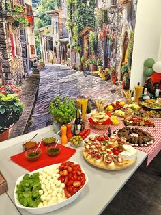 a table topped with lots of food next to a painting on the wall behind it