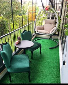 a balcony with chairs, table and hammock on the green carpeted floor