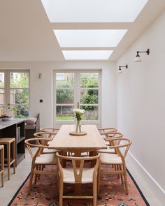 the dining room table is surrounded by chairs and an area rug that matches the floor