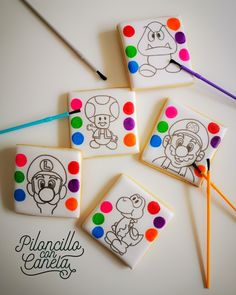 four decorated cookies sitting on top of each other with markers in front of the cookies