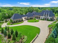 an aerial view of a large home in the middle of a lush green area with lots of trees