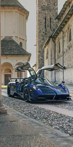 a blue sports car parked in front of a building