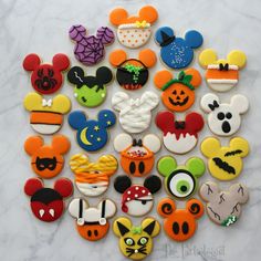 mickey mouse cookies are arranged in the shape of a pumpkin, ghost, and other characters