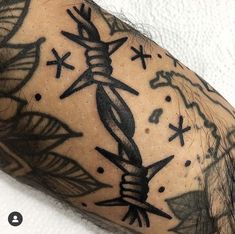 a man's arm with tattoos on it, and an arrow in the middle