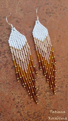 white and gold beaded earrings on a brown surface