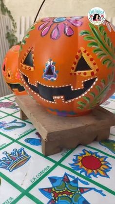 an orange painted pumpkin sitting on top of a wooden block