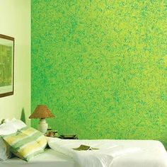 a bedroom with green paint on the walls and white bedding, along with two lamps