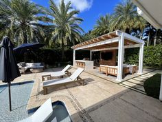 an outdoor patio with lounge chairs and umbrellas