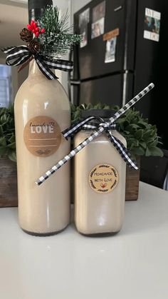 two glass bottles with christmas decorations tied to them