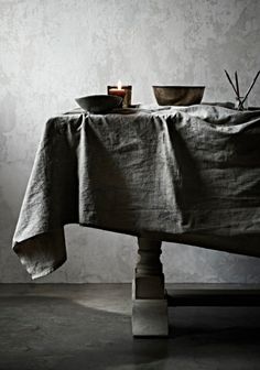 a table with a cloth draped over it and two bowls on top of the table