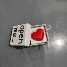 an open matchbox with a red heart in it and the word open written on it