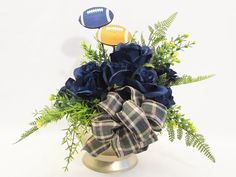 a bouquet of flowers in a vase with a football on the top and blue roses