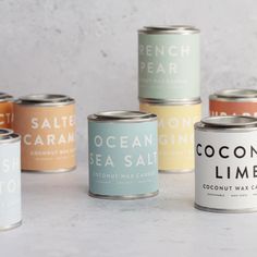 six cans of coconut wax sitting next to each other on a white counter top,