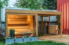 an outdoor sauna with hot tub in the middle and potted plants on the side