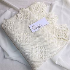 a white knitted pillow with a tag on it