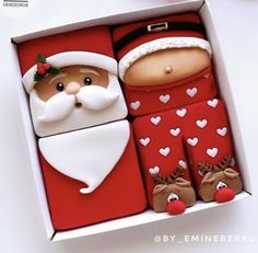 a santa clause cookie in a red box with white hearts on the bottom and feet