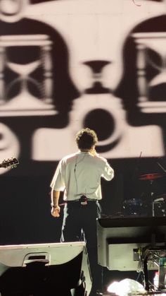 a man standing next to a keyboard on top of a stage