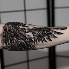 a black and white photo of an eagle tattoo on the arm