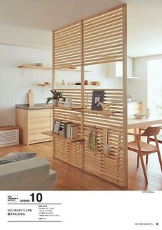 a living room filled with furniture next to a wooden table and wall mounted bookshelf