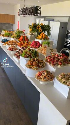 a kitchen filled with lots of food on top of white counter tops next to an oven