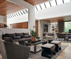 a living room filled with furniture and a wooden ceiling mounted to the side of a wall