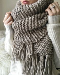 a woman wearing a gray knitted scarf