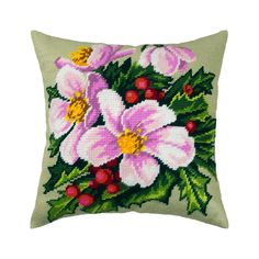 a cross stitched pillow with pink flowers on the front and green leaves around it