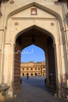 the entrance to an old building with people walking through it