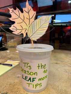 a cup with a leaf sticking out of it