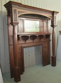 an old wooden fireplace in a room with white walls