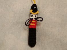 a crocheted keychain with a black and yellow bead on it