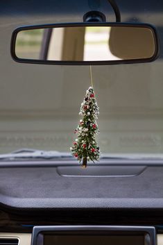 a small christmas tree hanging from the dash board of a car