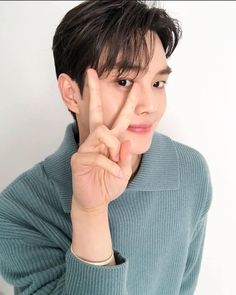 a young man is making the v sign with his fingers