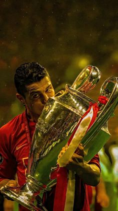 a soccer player kissing the trophy while holding it