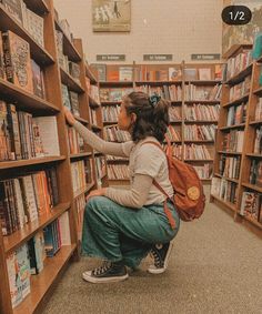 a woman is kneeling down in front of a bookshelf