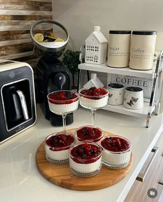 four desserts are sitting on a kitchen counter next to a toaster and coffee maker