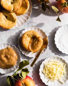 apples, biscuits and cheese are arranged on paper plates