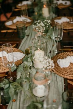 the table is set with candles, plates and napkins for an elegant wedding reception