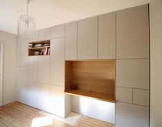 an empty room with some bookshelves on the wall and a light fixture hanging from the ceiling