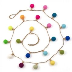 multicolored pom - pom string necklace on white background