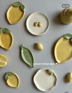 some yellow and white plates with green leaves on them are arranged next to each other