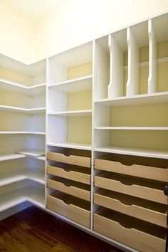 an empty walk in closet with lots of shelves