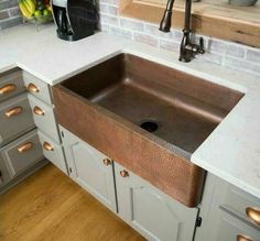 a kitchen sink sitting under a faucet next to a counter top and cabinets