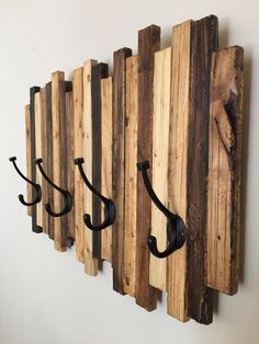 three hooks are attached to the wall with wood planks and metal brackets on them